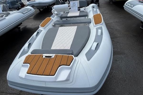 Gala A330HQE 2025 Gala A330HQE inflatable boat with wood accents and cushioned seating.