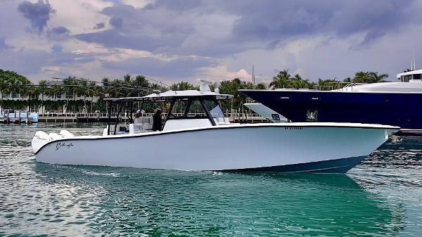 Yellowfin 42 Offshore 2022 Yellowfin 42 Offshore boat cruising on turquoise water under a cloudy sky.