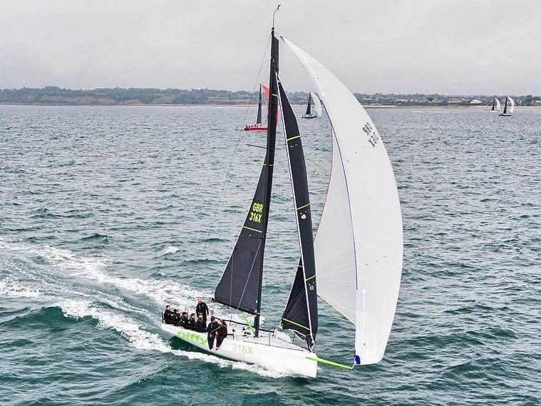 One Design Cape 31 Sailing yacht Cape 31, 2021 model, gliding on open water with crew onboard.