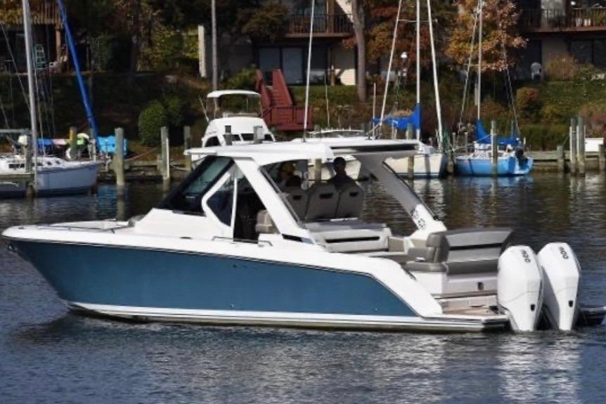 Tiara Yachts 34 LS 2023 Tiara Yachts 34 LS boat on water, featuring sleek design and dual engines.