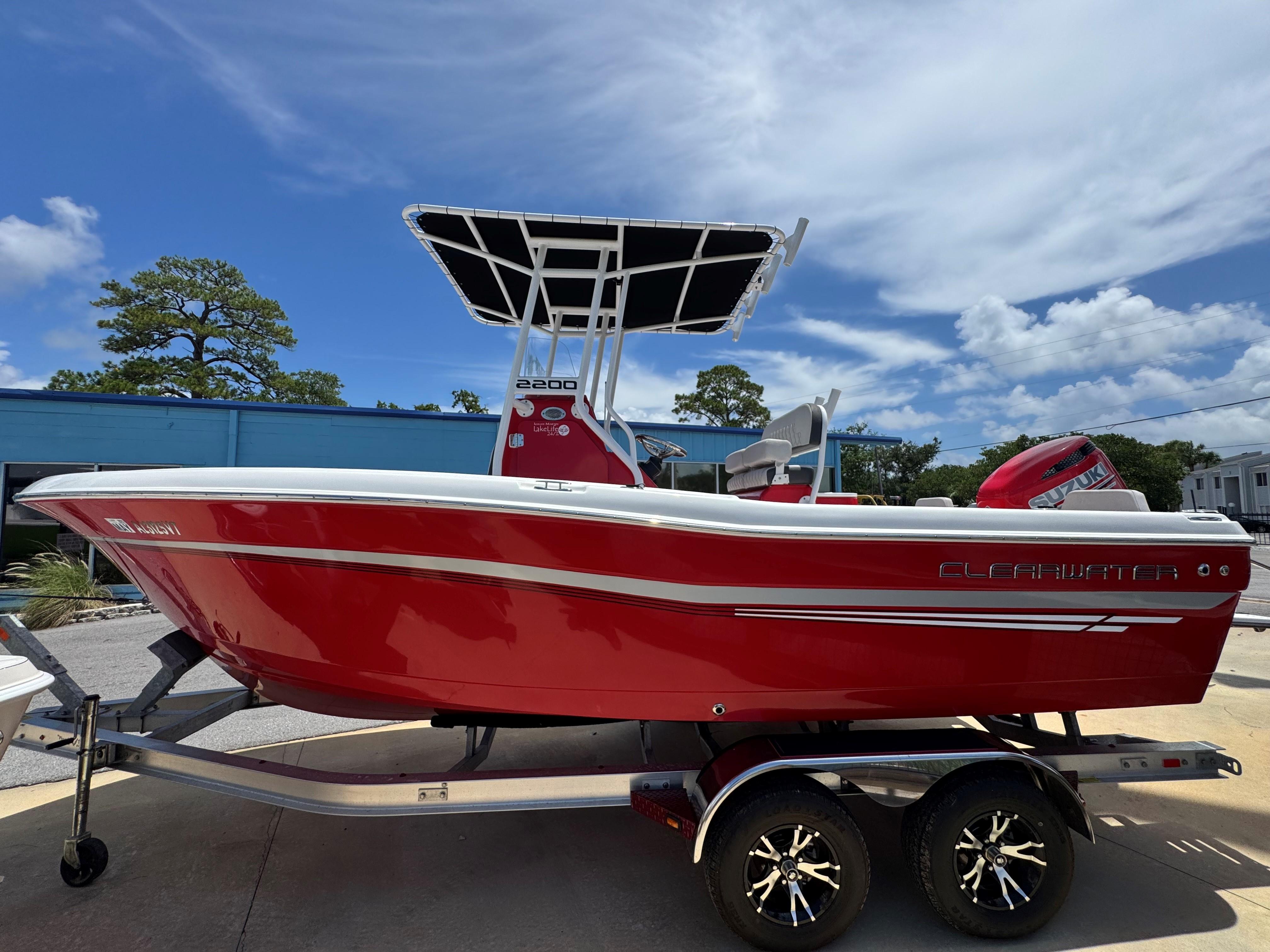 Clearwater 2200 Red 2023 Clearwater 2200 boat on trailer under blue sky.