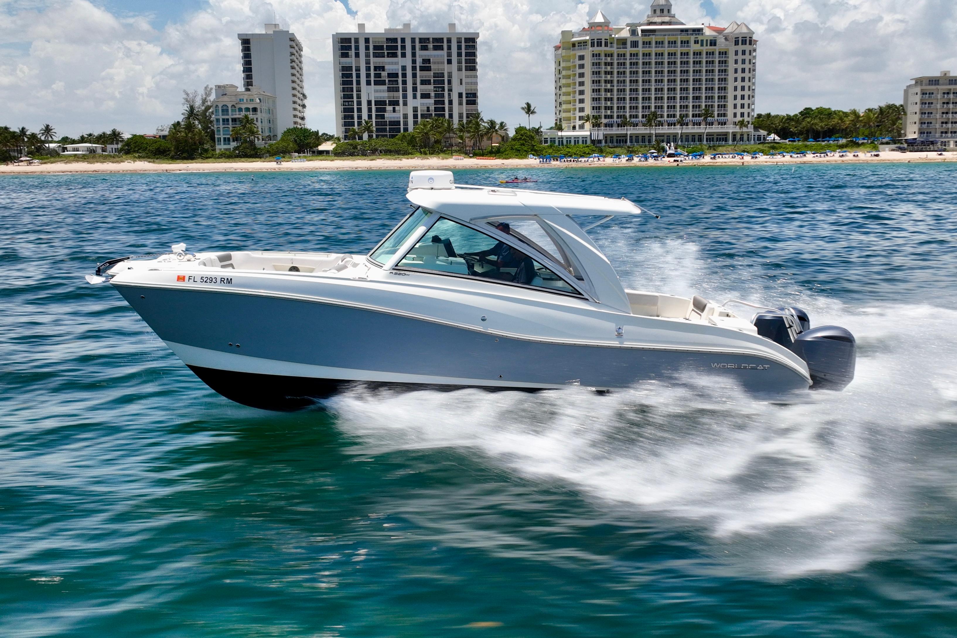 World Cat 320 DC 2018 World Cat 320 DC cruising on ocean near beachfront buildings.