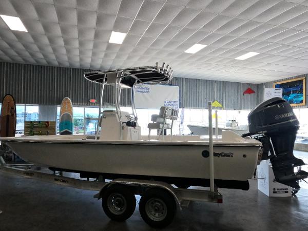 May-Craft 260 Bay 2023 May-Craft 260 Bay boat on trailer in showroom with Yamaha outboard motor.