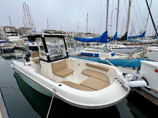 Bayliner Trophy T22CC 2022 Bayliner Trophy T22CC boat docked in a marina with sailboats.