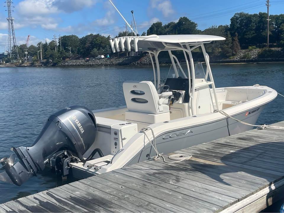 Cobia 220 Center Console 2021 Cobia 220 Center Console boat docked with Yamaha outboard motor.
