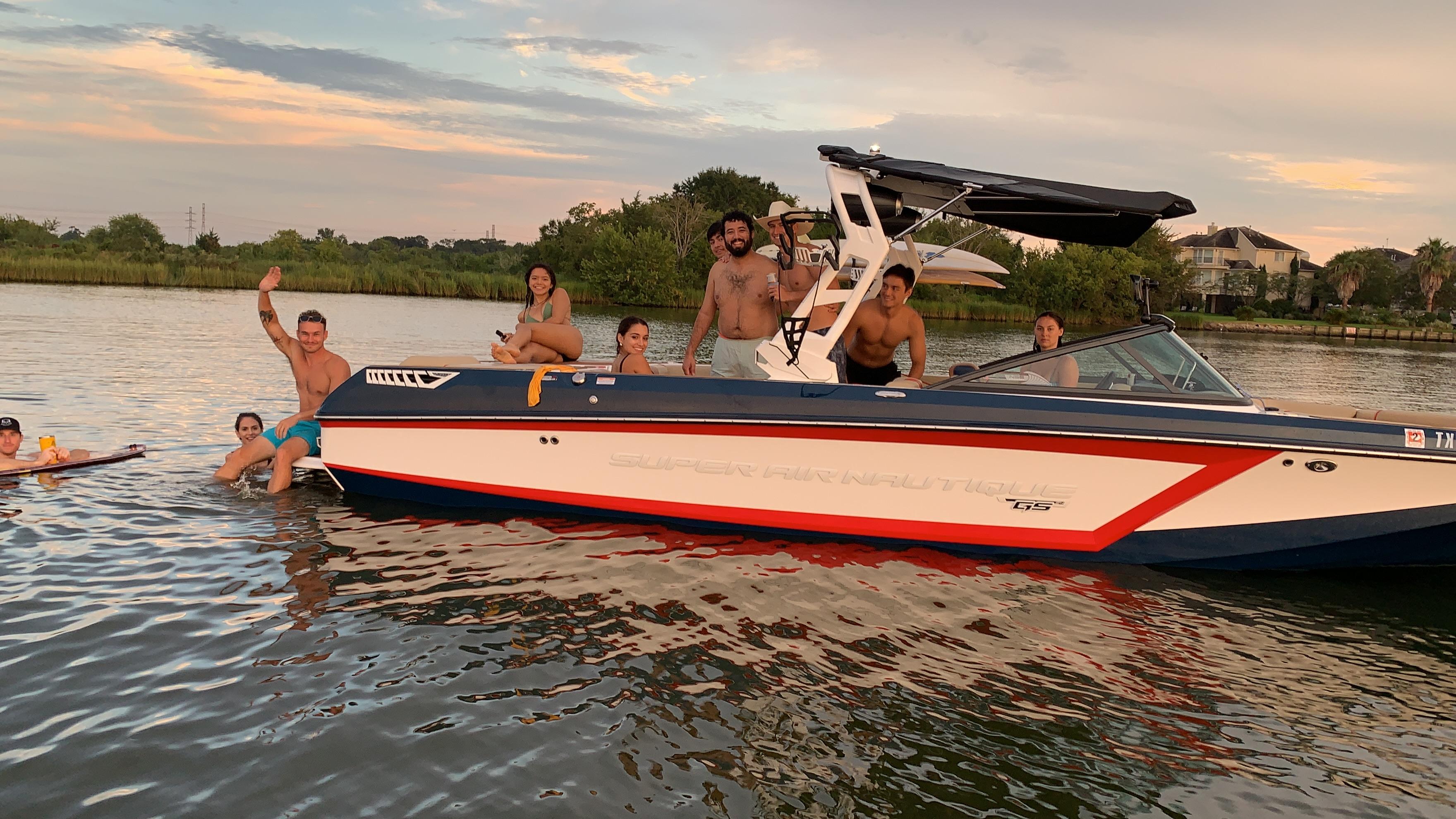 Nautique Super Air Nautique GS24 Group enjoying on a 2019 Nautique Super Air Nautique GS24 boat in a scenic waterway.