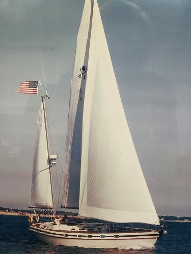 Contest 41 Ketch 1985 Contest 41 Ketch sailing with American flag on open water.