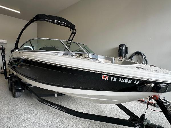 Chaparral 23 SSi OB 2020 Chaparral 23 SSi OB boat in garage, black and white exterior, on trailer.
