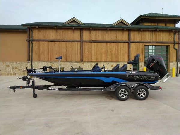 Nitro Z21 XL 2025 Nitro Z21 XL boat on trailer, parked outside a wooden building.
