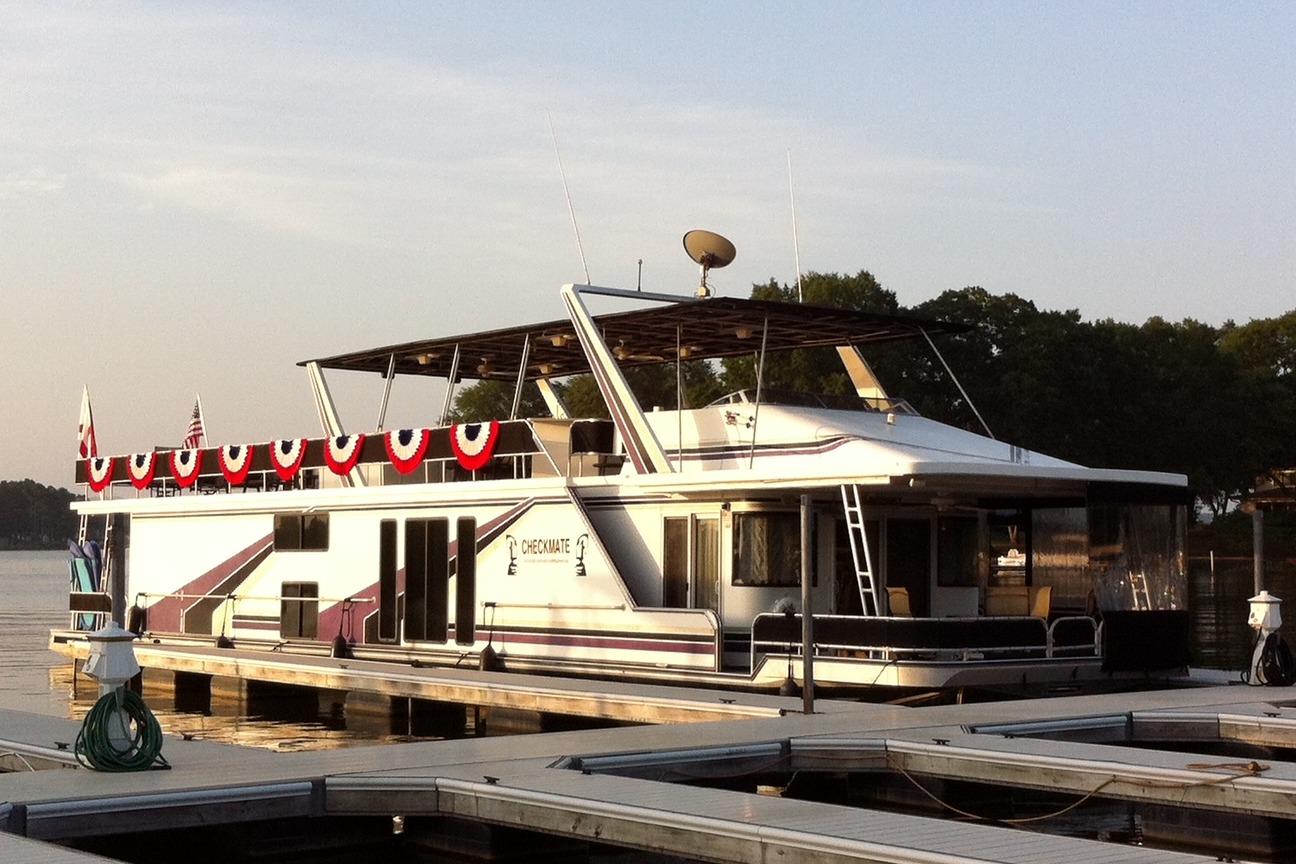 Sumerset 16x80 1998 Sumerset 16x80 houseboat docked, decorated with patriotic bunting, under a clear sky.