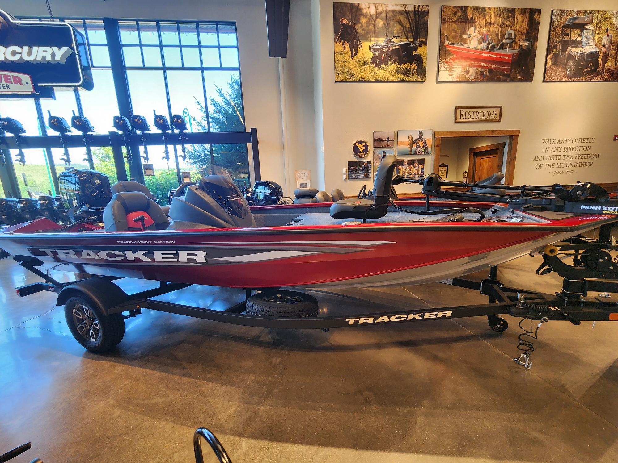Tracker Pro Team 175 2025 Tracker Pro Team 175 boat displayed in showroom, red color, on trailer.
