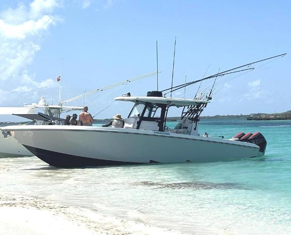 Fountain 34 Tournament Edition 2024 Fountain 34 TE boat anchored on a sandy beach with people onboard.