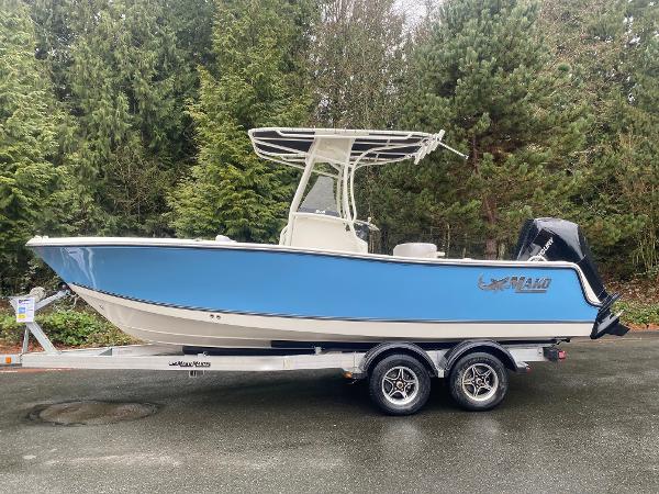 Mako 214 CC 2025 Mako 214 CC boat on trailer, blue hull, parked outdoors.