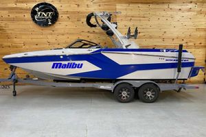 Malibu Wakesetter 23 MXZ 2024 Malibu Wakesetter 23 MXZ boat on trailer in showroom.