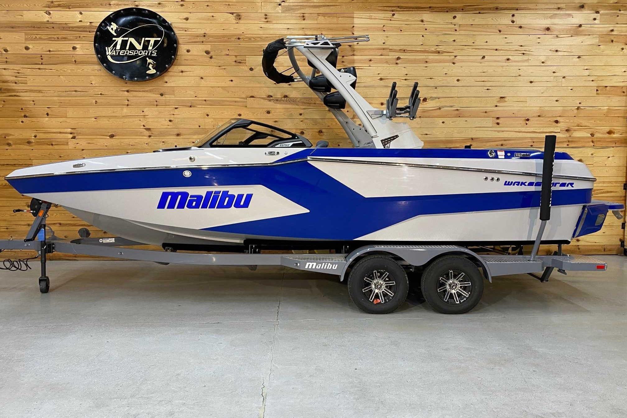 Malibu Wakesetter 23 MXZ 2024 Malibu Wakesetter 23 MXZ boat on trailer in showroom.