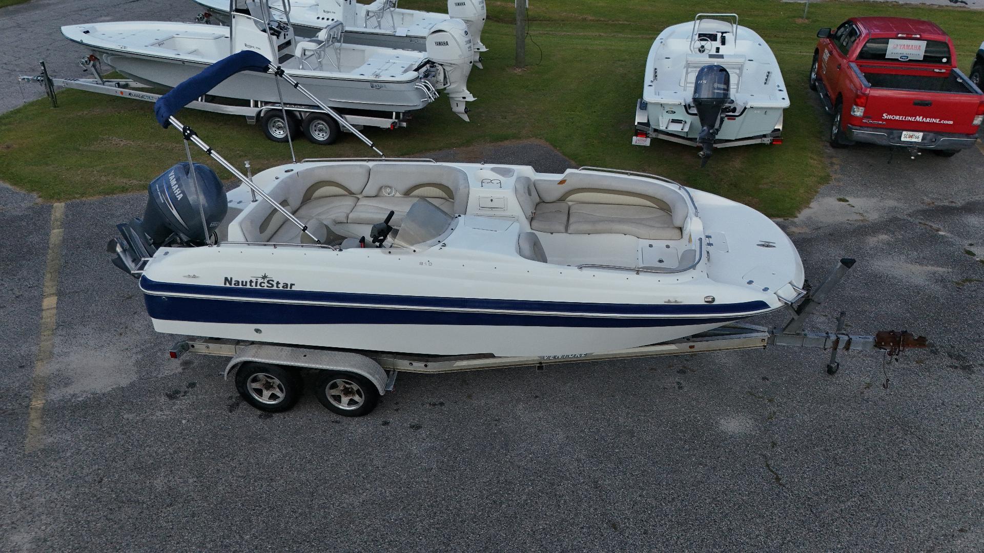 NauticStar 210 SC 2010 NauticStar 210 SC boat on trailer, parked in a lot with other boats.