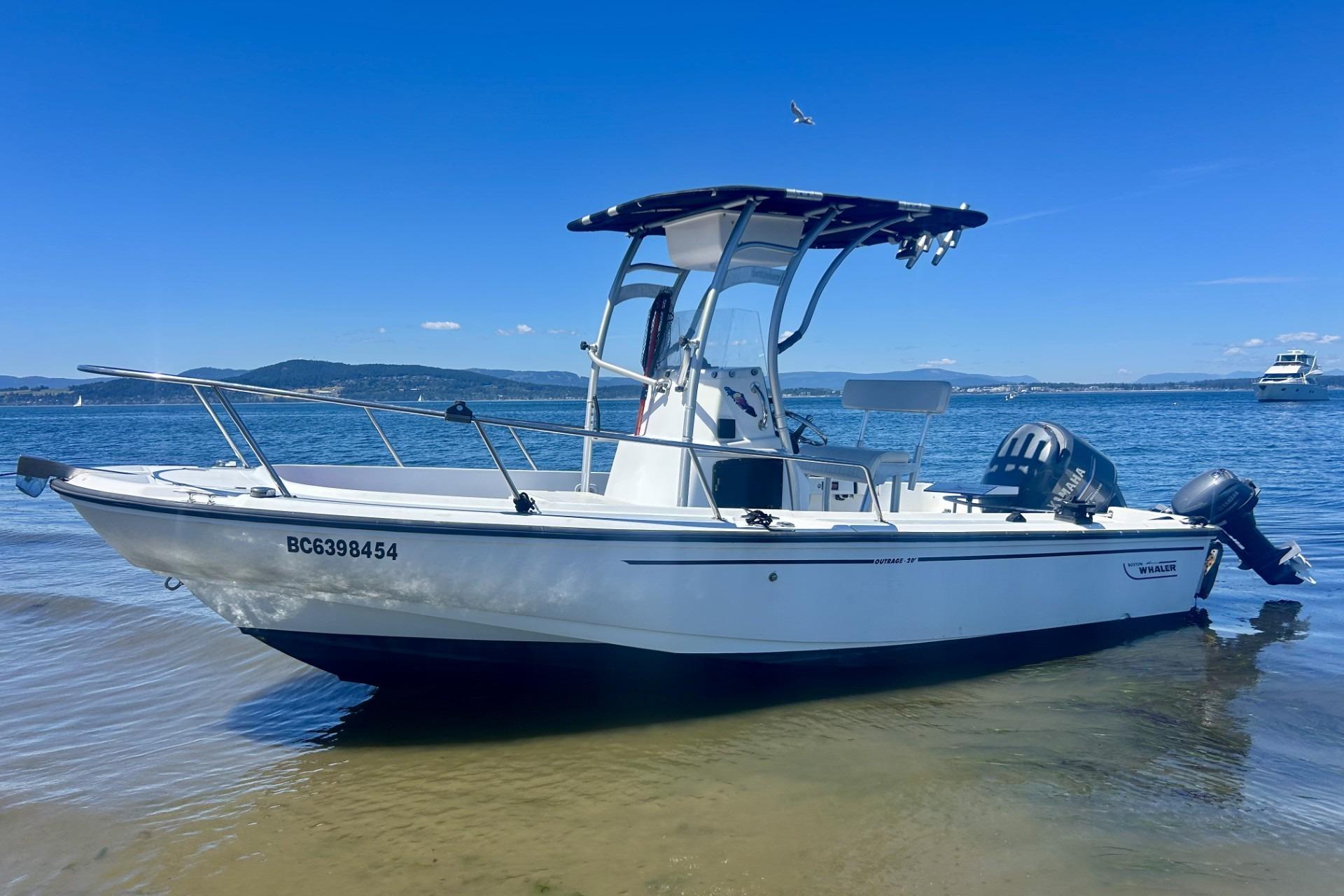 Boston Whaler Outrage 20 1997 Boston Whaler Outrage 20 boat on calm water under clear blue sky.