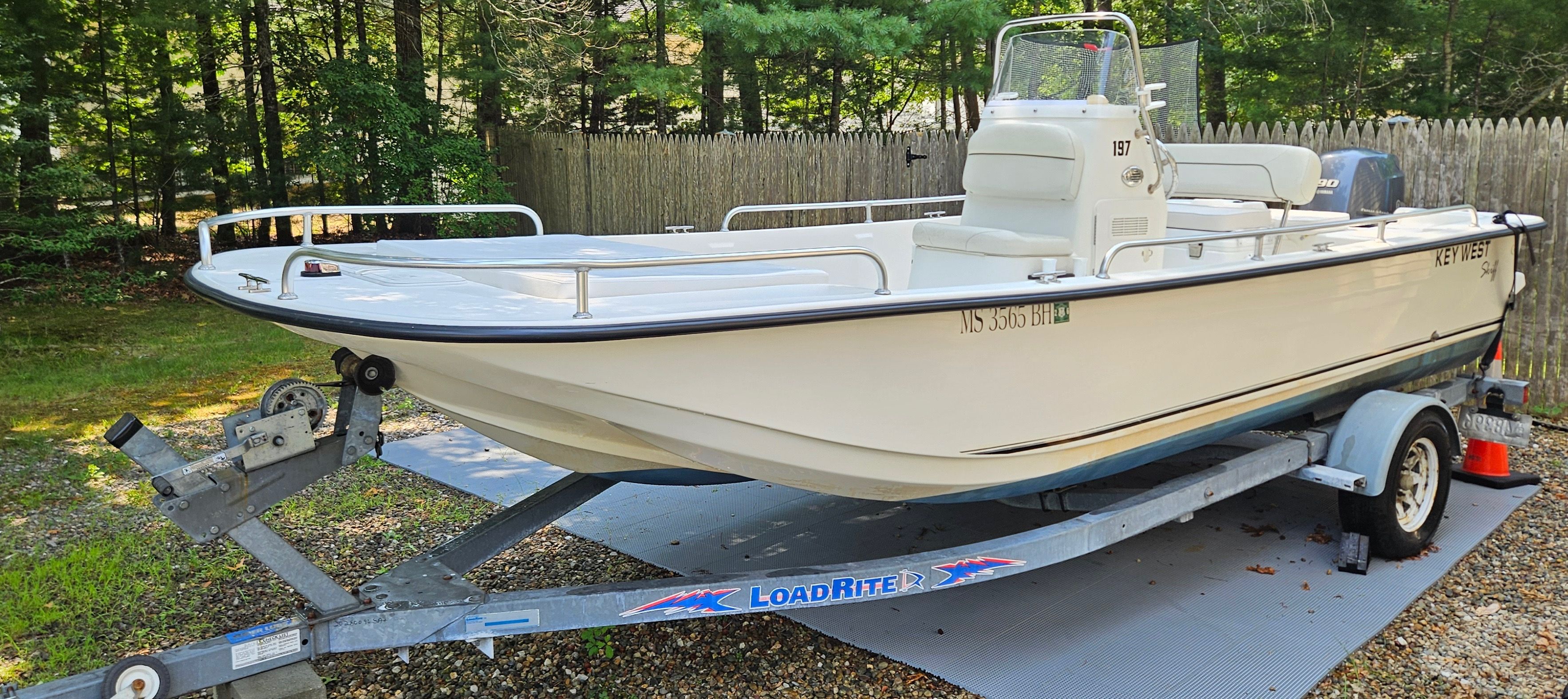 Key West 197 Skiff 2014 Key West 197 Skiff boat on trailer in wooded area.