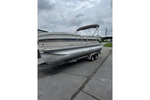 Premier 225 Legend 2006 Premier 225 Legend pontoon boat on trailer, parked on asphalt under cloudy sky.