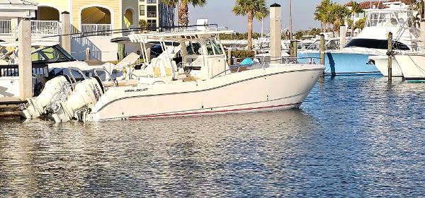 World Cat 320 2016 World Cat 320 boat docked at marina with palm trees in background.