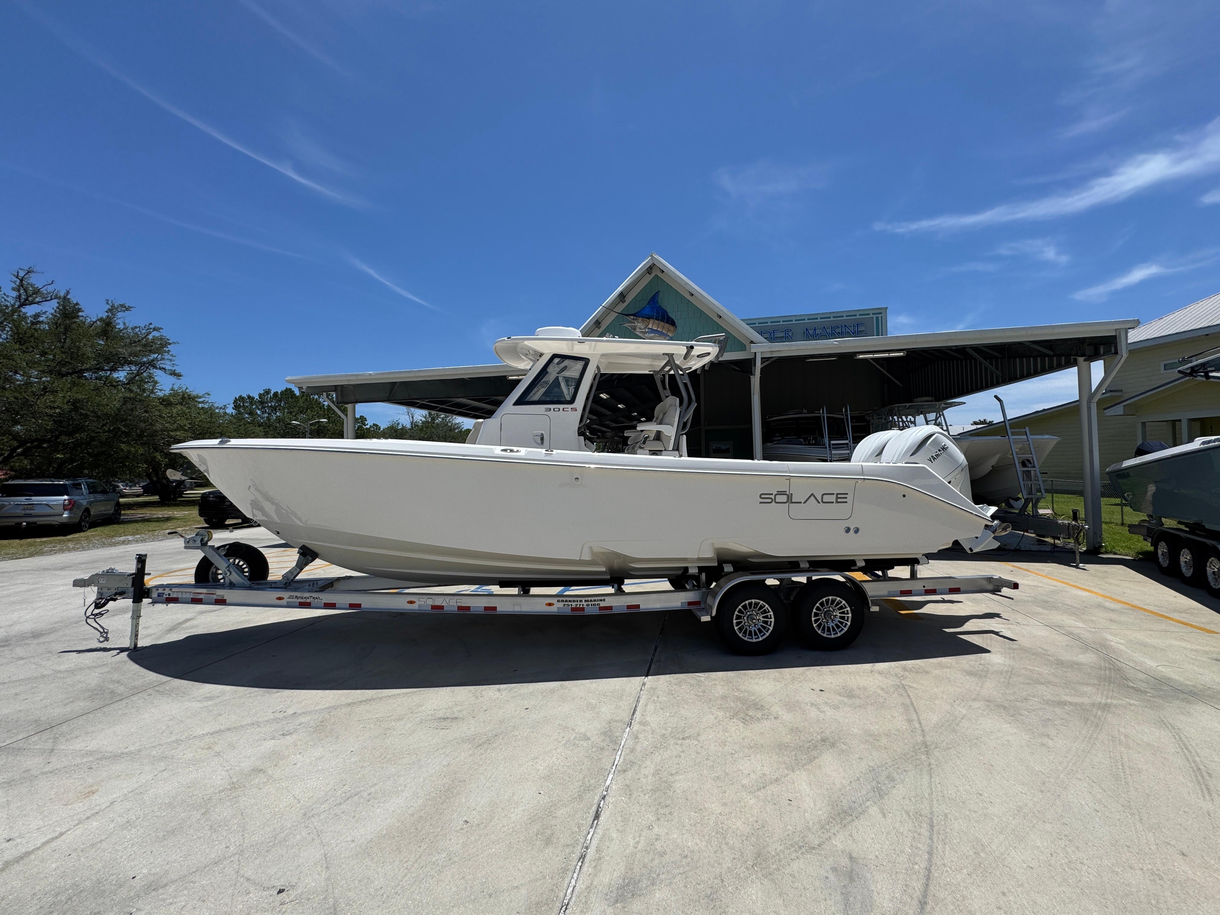 Solace 30 CS 2026 Solace 30 CS boat on trailer under clear blue sky.