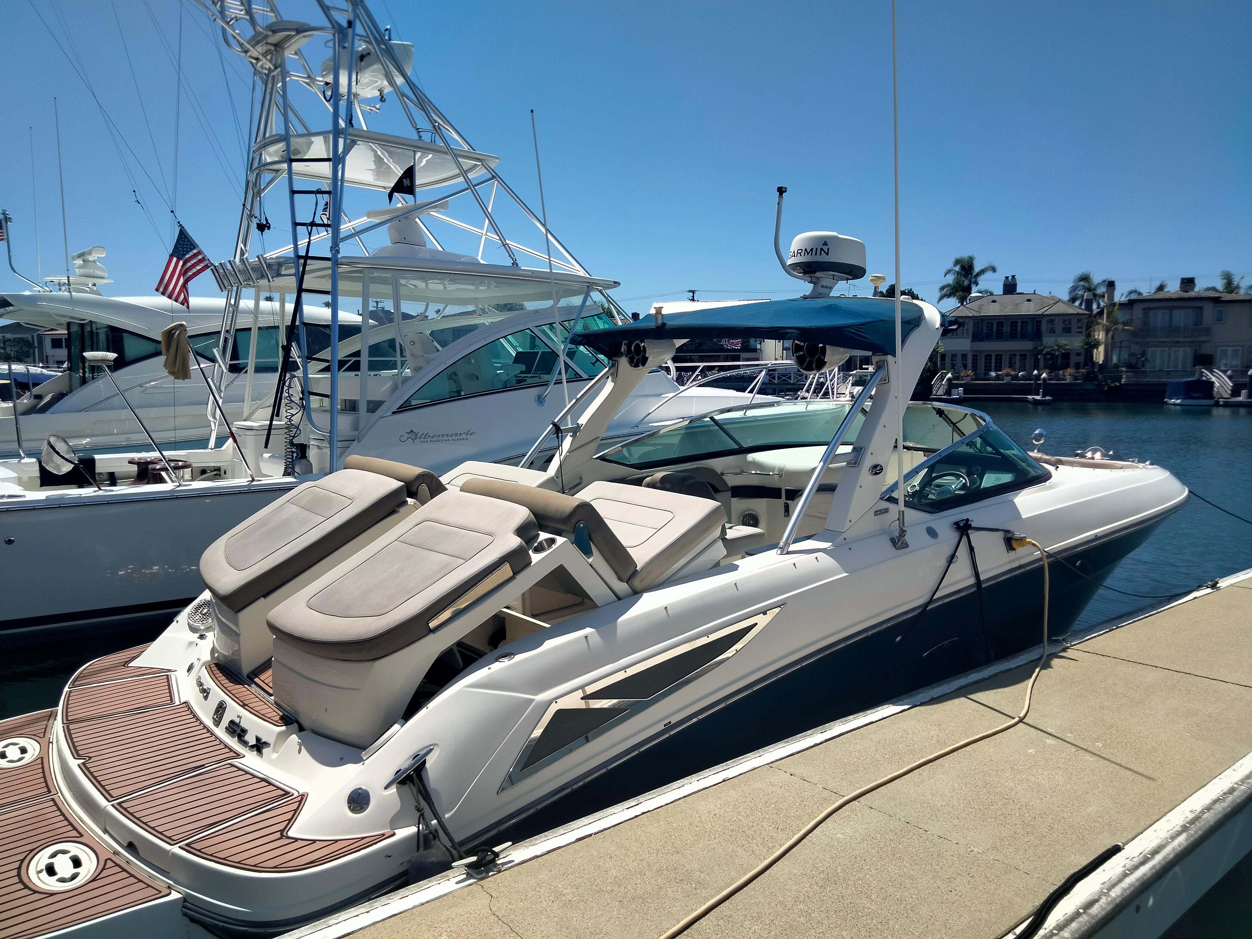Sea Ray 30 SLX 2012 Sea Ray 30 SLX luxury boat docked at marina under clear blue sky.