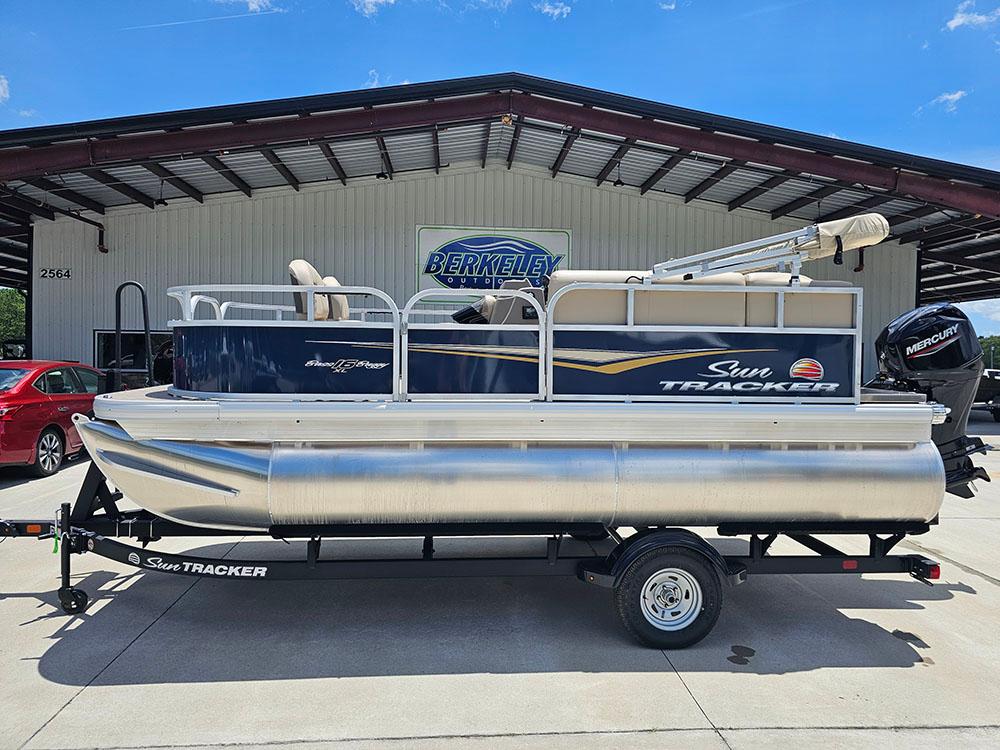 Sun Tracker Bass Buggy 16 XL Select 2025 Sun Tracker Bass Buggy 16 XL Select pontoon boat on trailer, parked outdoors.