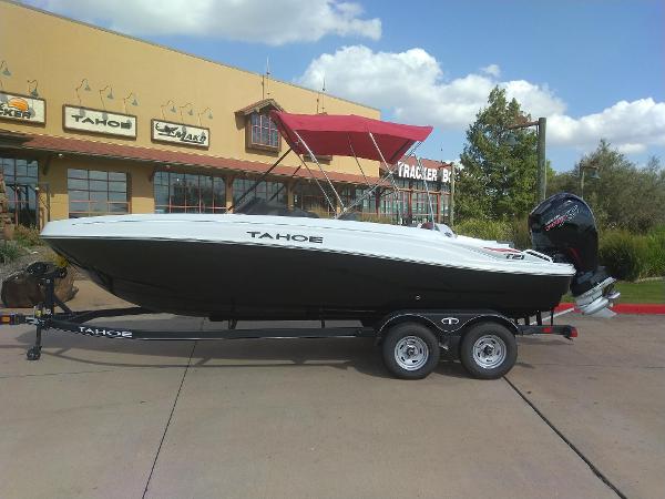 Tahoe T21 2024 Tahoe T21 boat on trailer with red canopy, parked outside dealership.