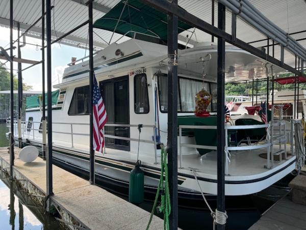 Gibson 44 Standard 1994 Gibson 44 Standard houseboat docked with American flag and green canopy.