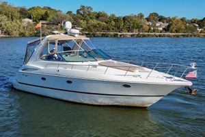 Cruisers Yachts 3672 Express 2001 Cruisers Yachts 3672 Express on a serene lake with lush green shoreline.