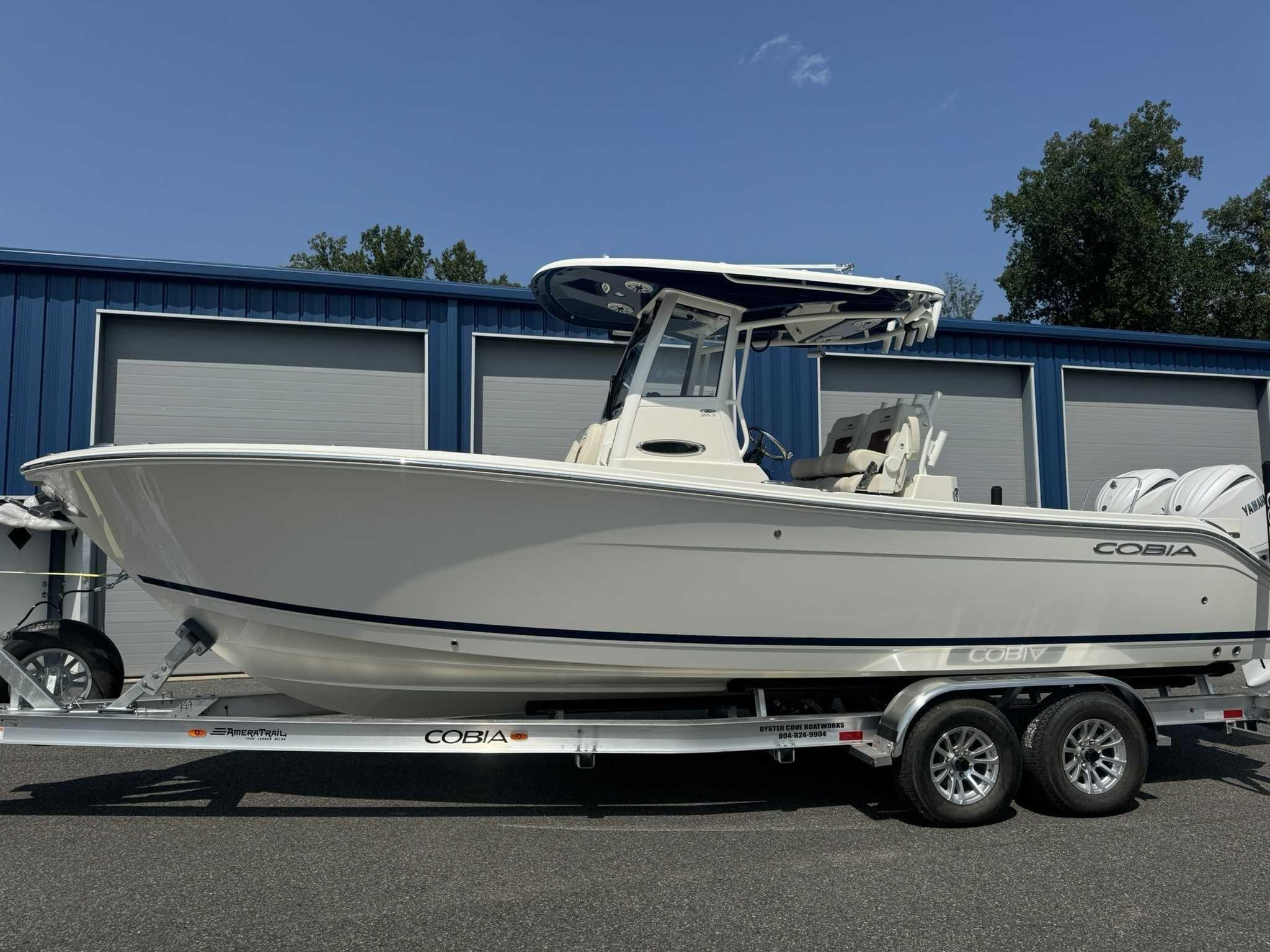 Cobia 265 Center Console 2025 Cobia 265 Center Console boat on trailer, parked outside blue storage units.