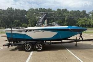 Tigé RZX2 2017 Tigé RZX2 boat on trailer, blue and white, parked outdoors.