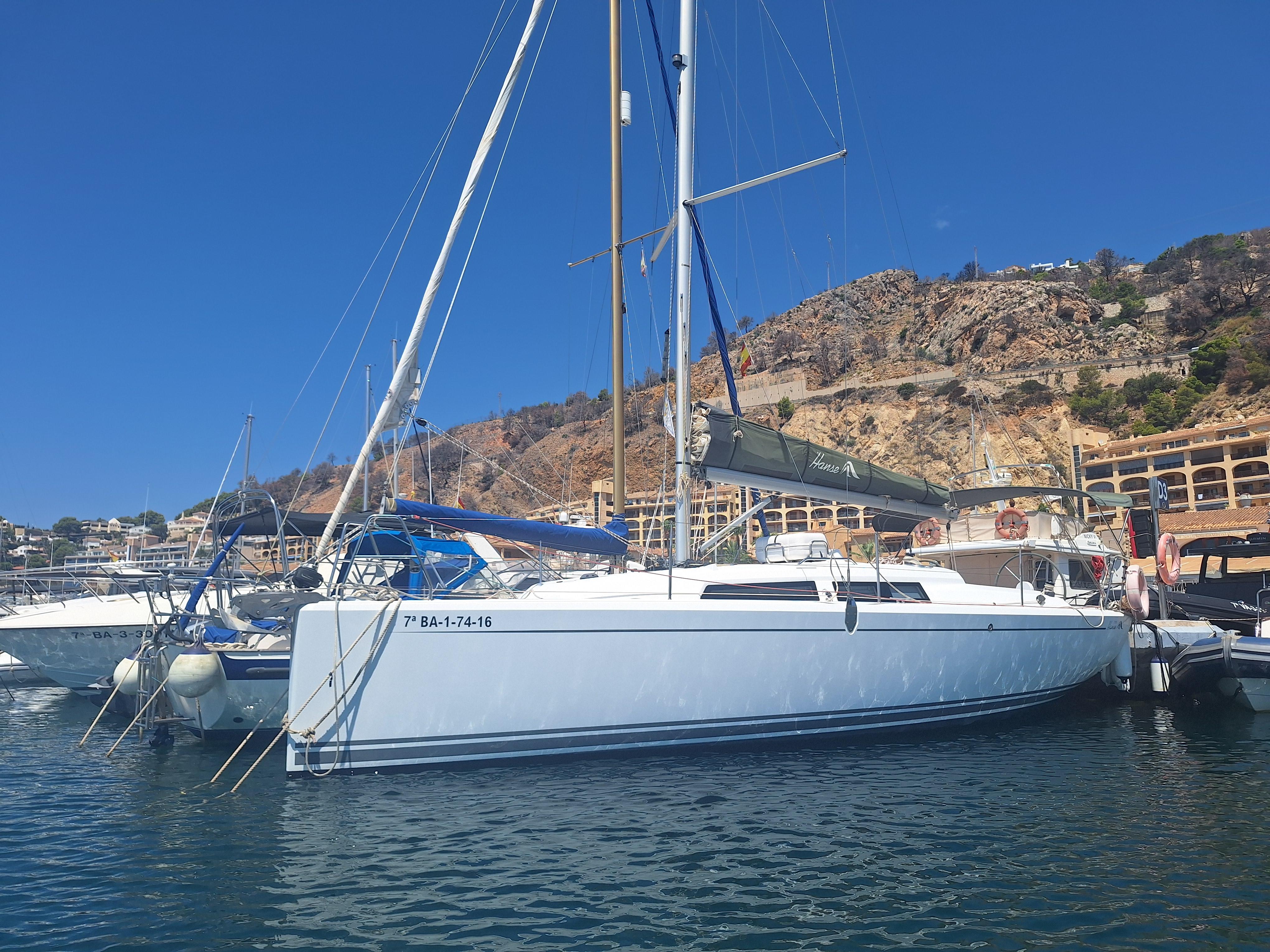 Hanse 315 2016 Hanse 315 sailboat docked in a marina with rocky hills in the background.