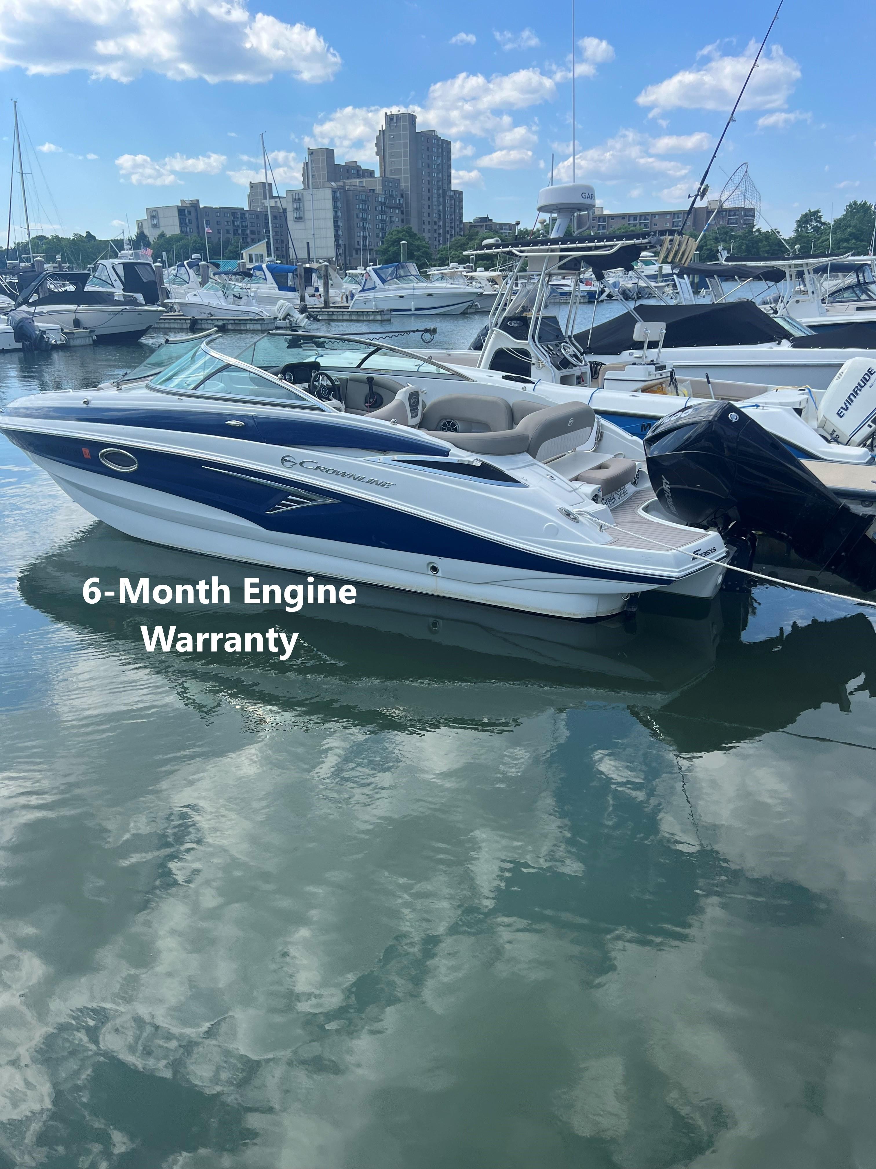 Crownline E235XS 2023 Crownline E235XS boat docked, featuring a 6-month engine warranty.