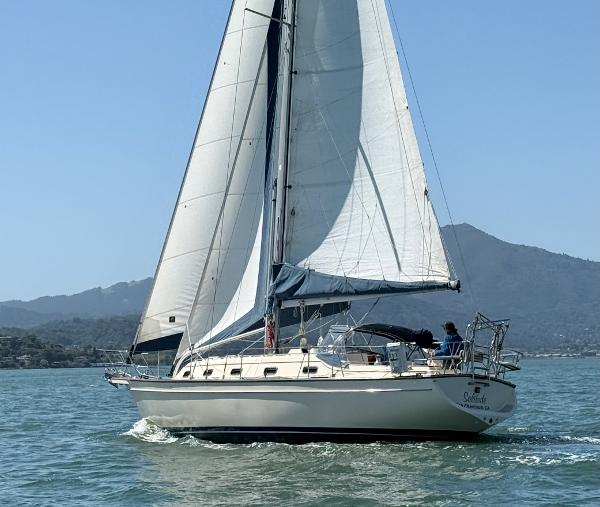 Island Packet 380 Sailing yacht Island Packet 380, 1999 model, cruising on calm waters with mountains in the background.