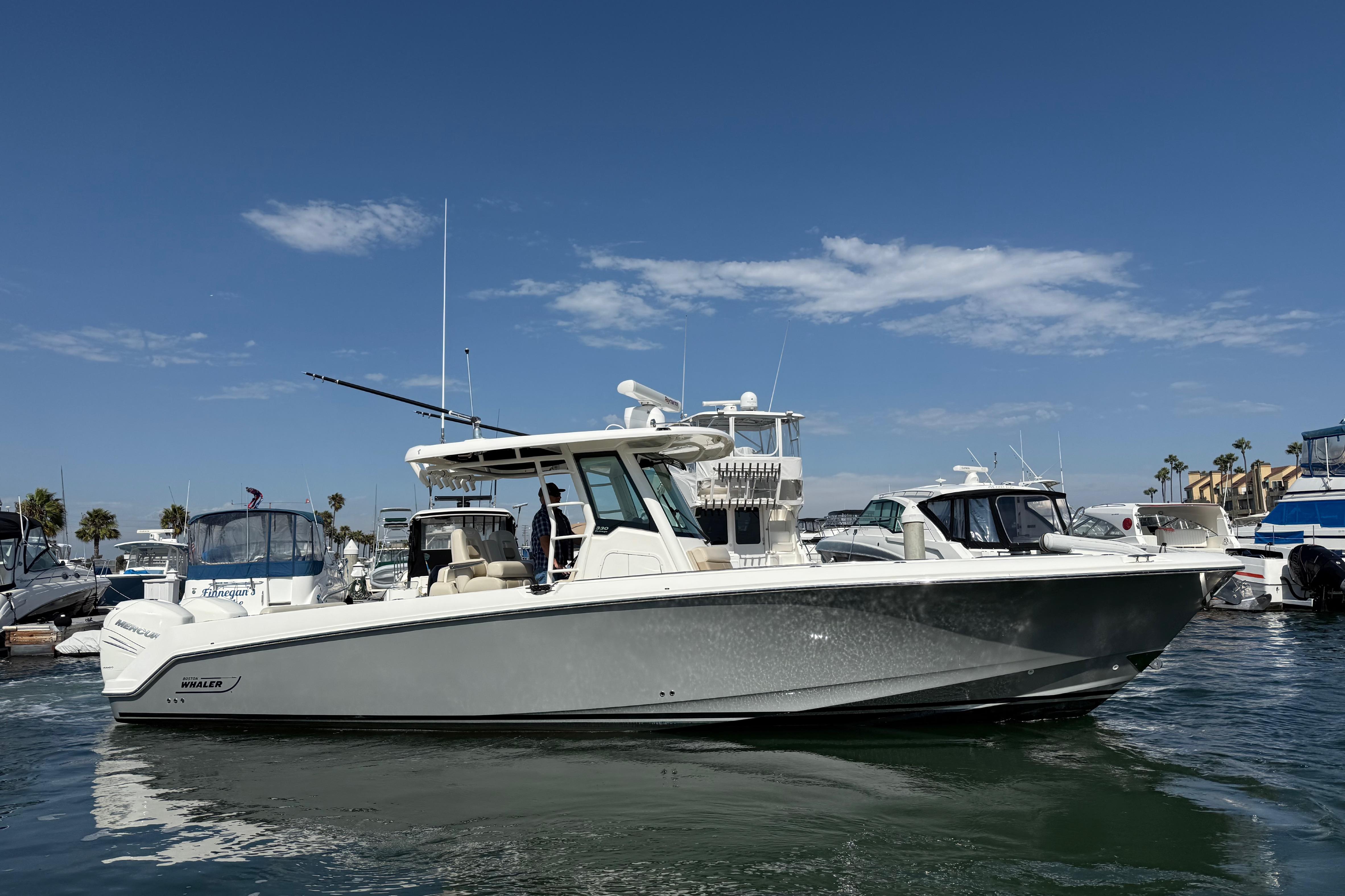 Boston Whaler 330 Outrage 2019 Boston Whaler 330 Outrage boat docked in a marina under a clear blue sky.