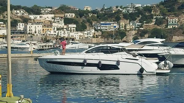 Azimut Atlantis 45 2020 Azimut Atlantis 45 yacht docked in a scenic marina with hillside buildings.