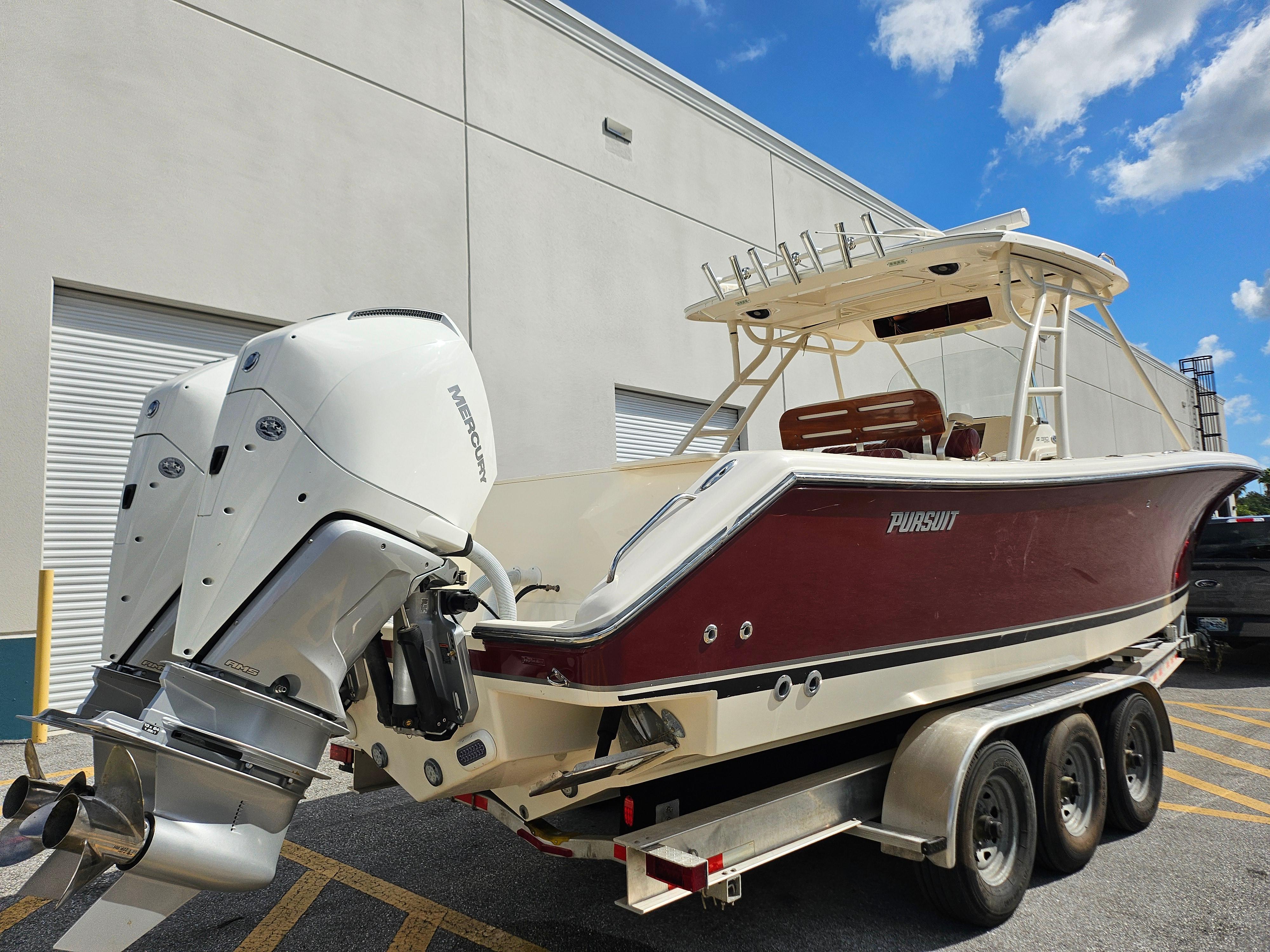 Pursuit C 310 Center Console 2012 Pursuit C 310 Center Console boat on trailer, featuring dual Mercury outboard engines.