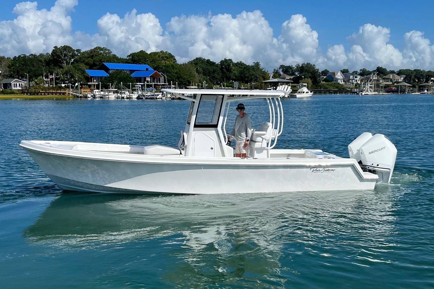 Pair Customs 27 Center Console 2026 Pair Customs 27 Center Console boat on calm water, with scenic background.