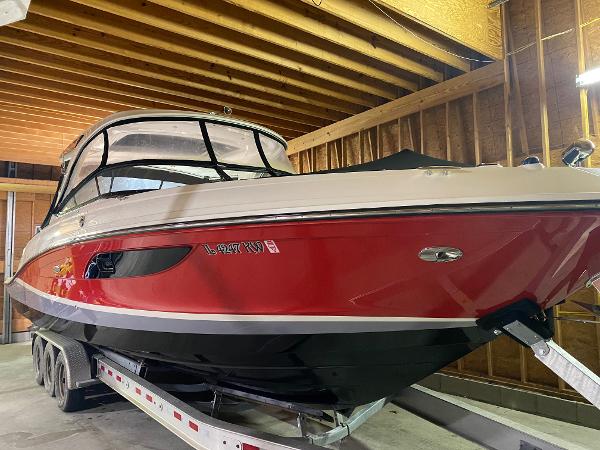 Sea Ray SLX 350 Outboard 2017 Sea Ray 350 SLX boat in storage, red and black exterior, on a trailer.