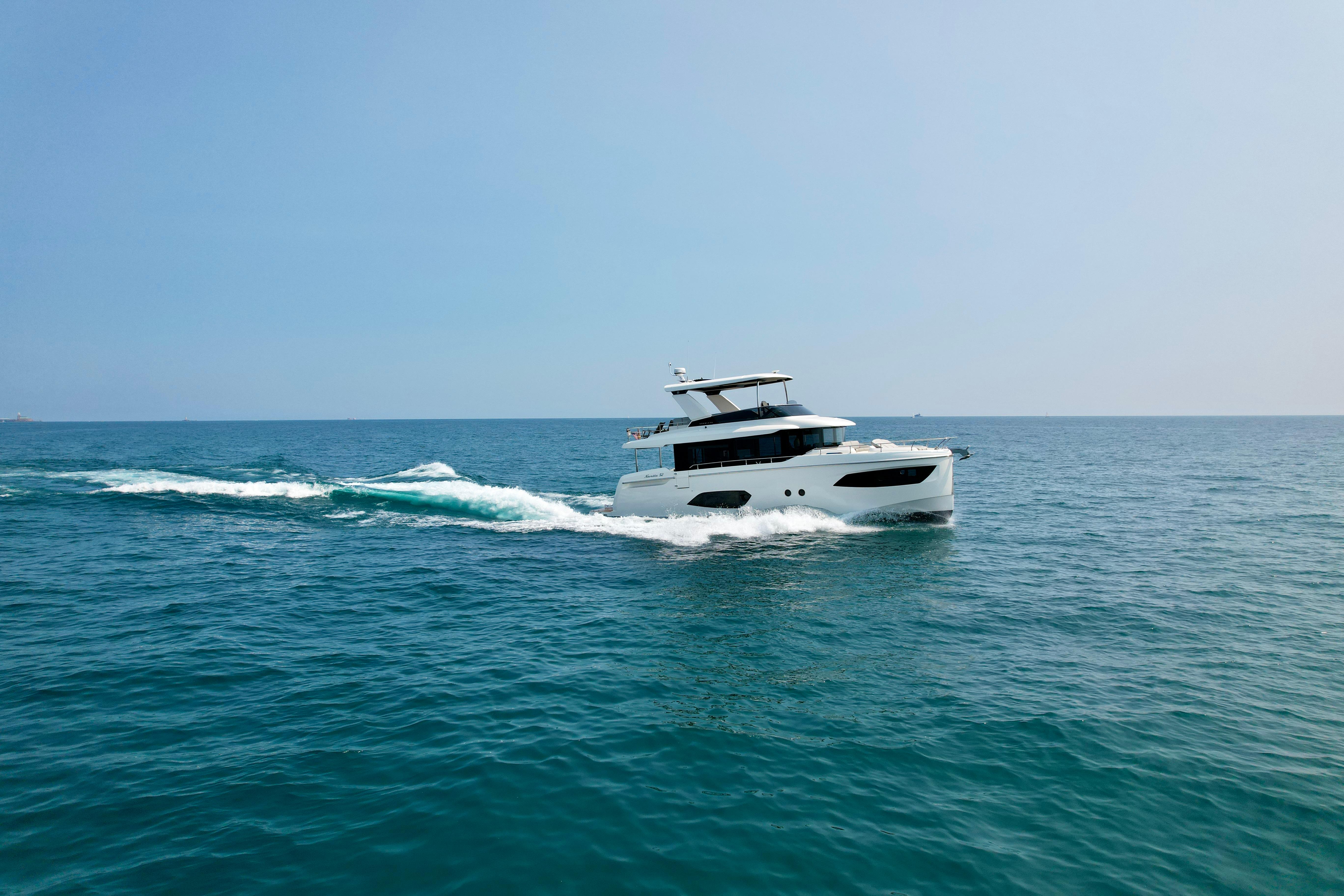 Absolute 52 Navetta 2023 Absolute 52 Navetta yacht cruising on open sea under clear sky.