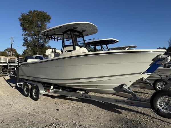 Cobia 240 Center Console 2025 Cobia 240 Center Console boat on trailer, parked outdoors under clear blue sky.