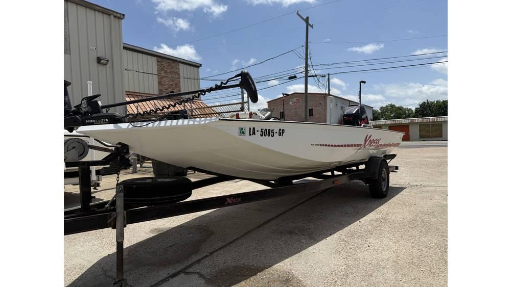 Xpress X19 2000 Xpress X19 boat on trailer, parked outdoors under a clear sky.
