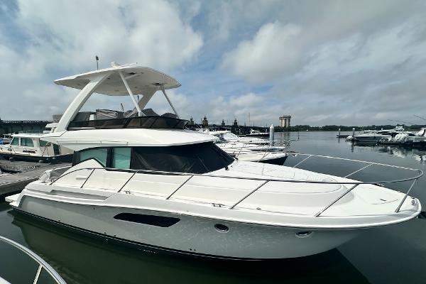Tiara Yachts F44 Flybridge 2021 Tiara Yachts F44 Flybridge, sleek design, docked in marina under cloudy sky.