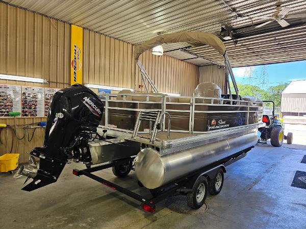 Sun Tracker SportFish 20 DLX 2025 Sun Tracker SportFish 20 DLX pontoon boat in a garage, featuring a Mercury outboard motor.