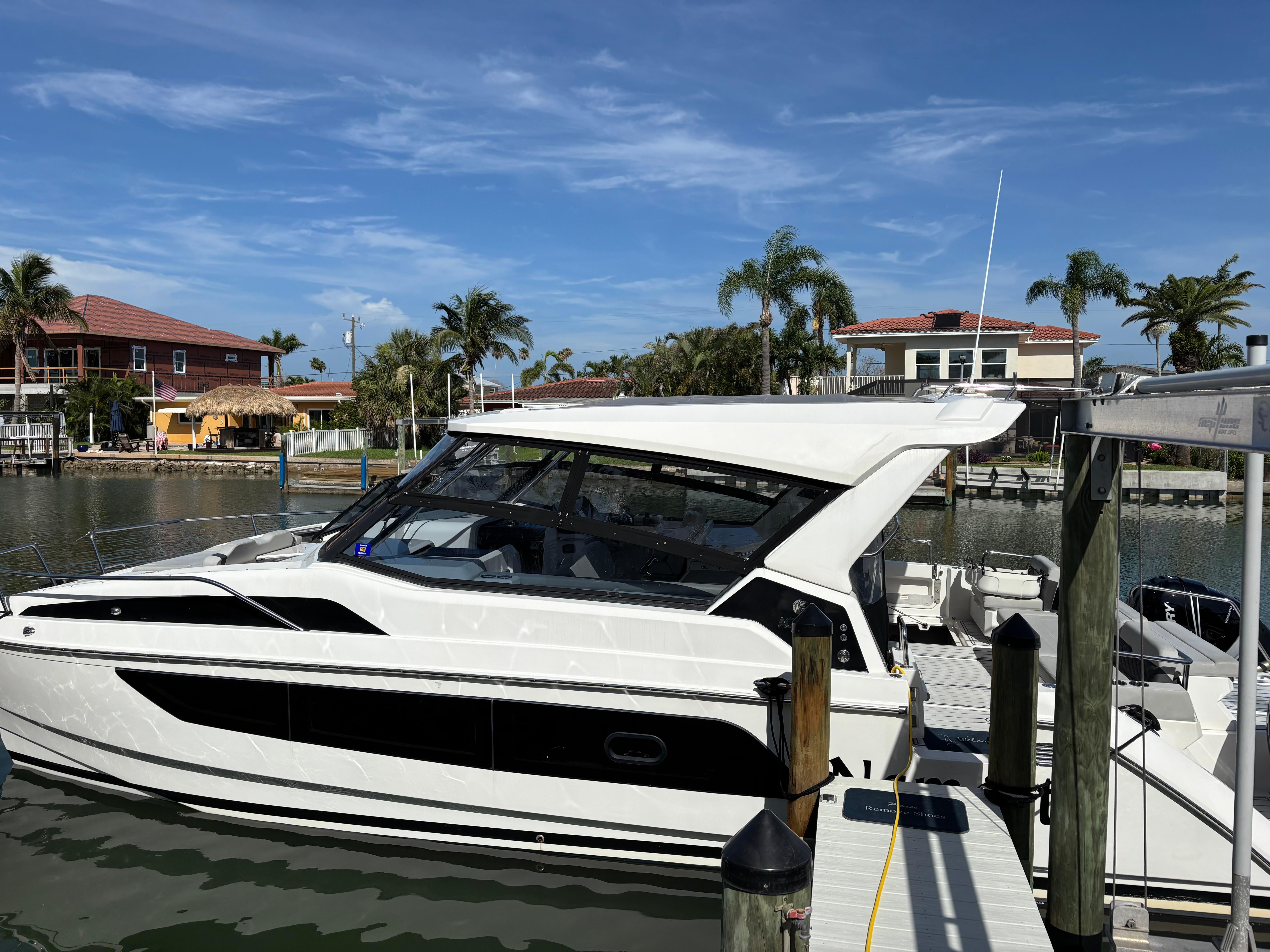 Aquila 36 Sport Aquila 36 Sport 2018 docked at a marina with palm trees and waterfront homes.