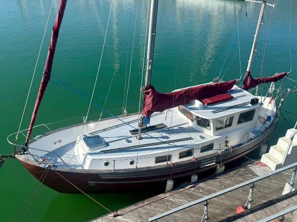 Fisher 34 Pilothouse Ketch 1985 Fisher 34 Pilothouse Ketch docked, featuring maroon sails and a classic design.