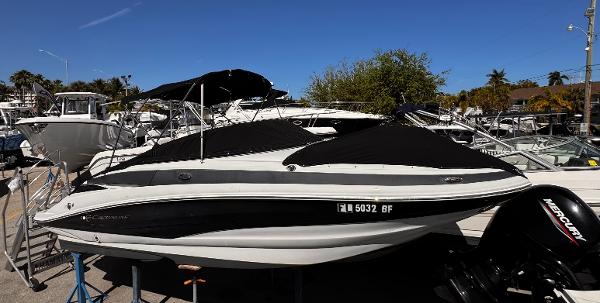 Crownline E2 2016 Crownline E2 boat with Mercury engine, docked among other boats under a clear blue sky.
