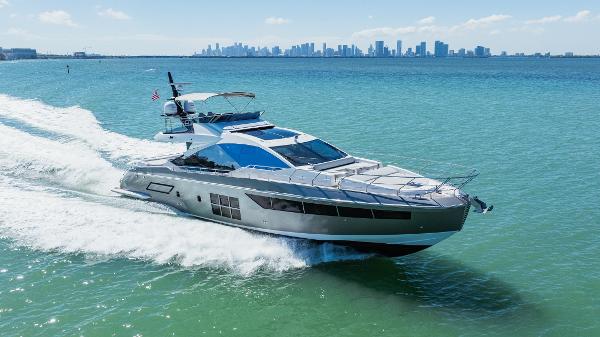 Azimut S7 2018 Azimut S7 yacht cruising on blue ocean with city skyline in background.