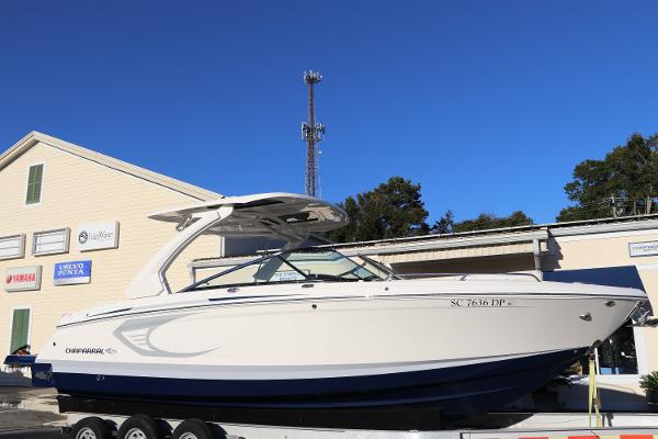 Chaparral 30 Surf 2021 Chaparral 30 Surf boat on trailer, parked outside a building under clear blue sky.
